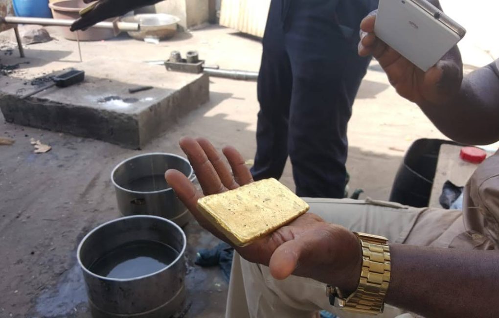 A man showcases a gold bar, highlighting the progress of gold mining at the new Liberia mining company site