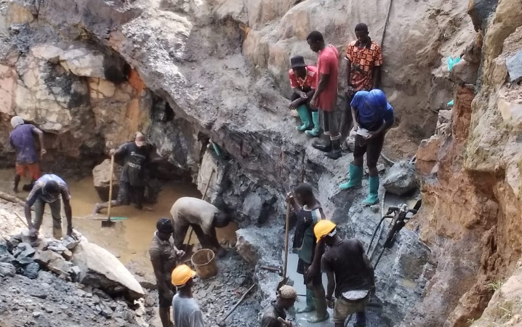 Workers extract gold in a large pit at the New Liberia Mining Company, showcasing the mining process in action