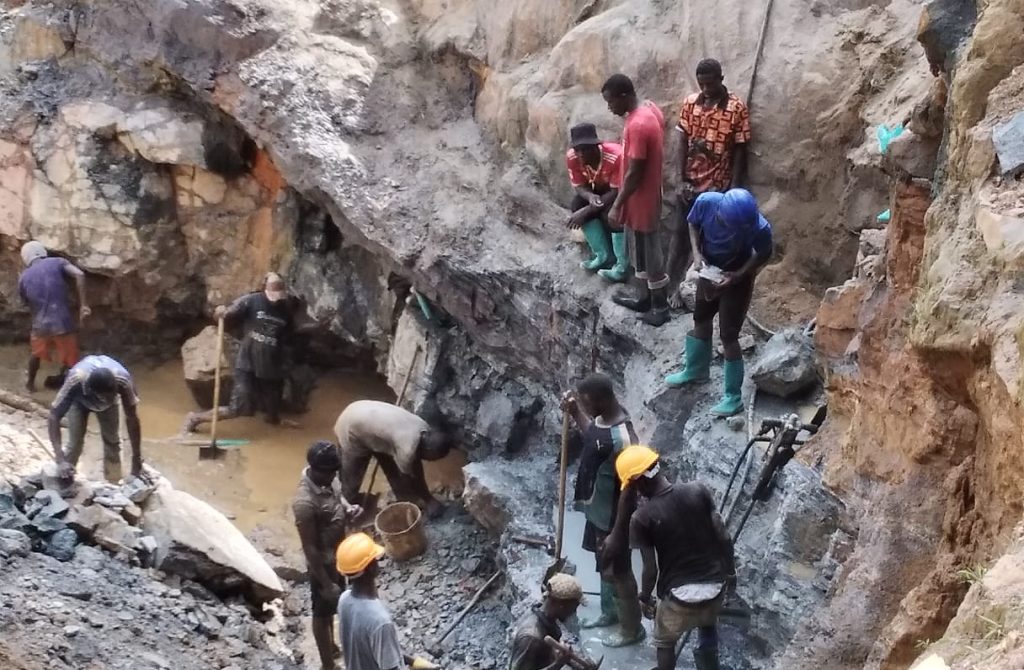 Workers extract gold in a large pit at the New Liberia Mining Company, showcasing the mining process in action